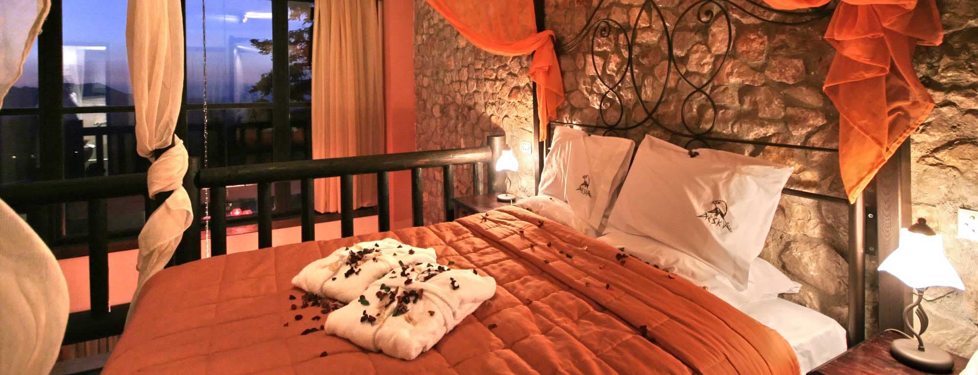 Το κρεβάτι του επάνω ορόφου της Grand Suite, με το παράθυρο στο σούρουπο